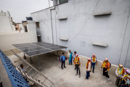 Die Teilnehmer*innen der Studienreise besichtigen die von Maanaveeya gespendete Solaranlage auf dem Dach. 
